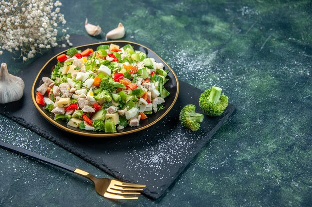 front view tasty vegetable salad inside plate on dark-blue background