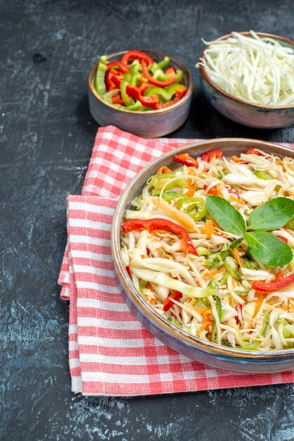 灰色のテーブルにスライスしたキャベツとピーマンの正面図おいしい野菜サラダ