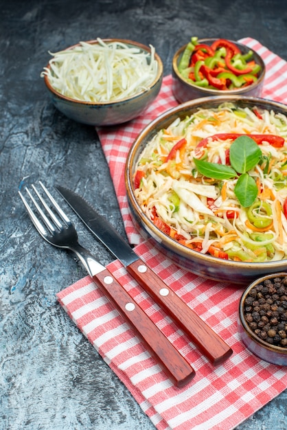 Front view tasty vegetable salad with sliced cabbage and bell-peppers on grey table