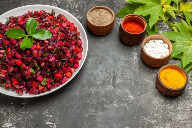 Вид спереди вкусный винегрет свекольный салат с приправами на темном фоне