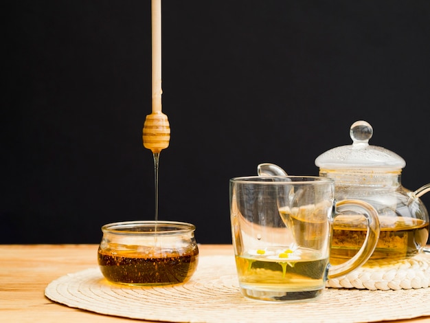 Front view teapot with glass and honey