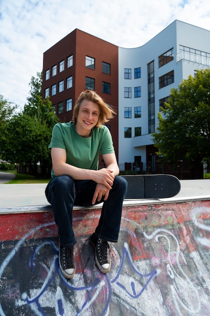 Front view teen holding skateboard