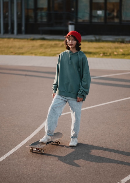 Front view of teenager outdoor with skateboard