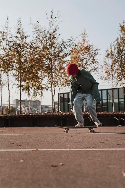 Foto gratuita vista frontale dell'adolescente con lo skateboard all'aperto