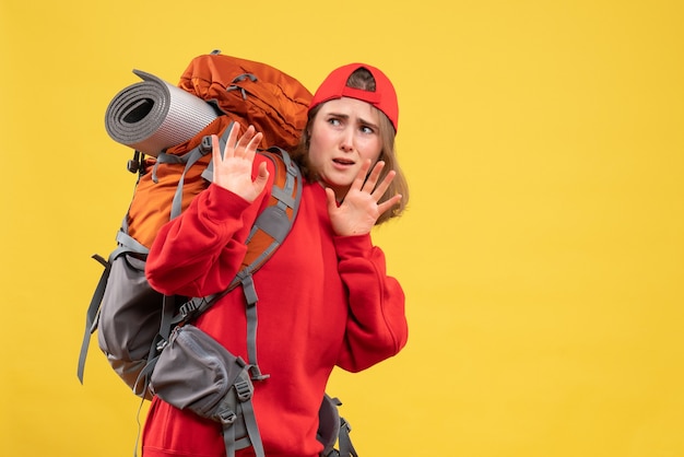Вид спереди испуганная женщина-путешественница в красном рюкзаке