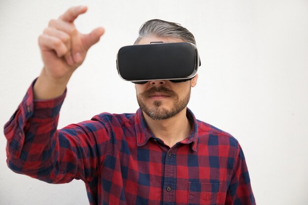 Вид спереди тестера с очками VR, пытающимися что-то поймать