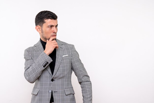 Front view thinking handsome male in suit standing on white isolated background