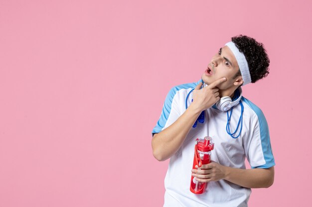 Front view thinking male athlete in sport clothes with skipping ropes