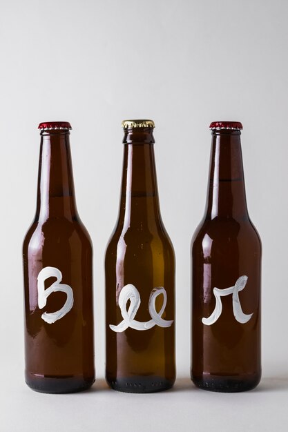 Front view three bottles of beer aligned on table