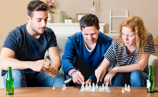 Free photo front view of three friends playing chess