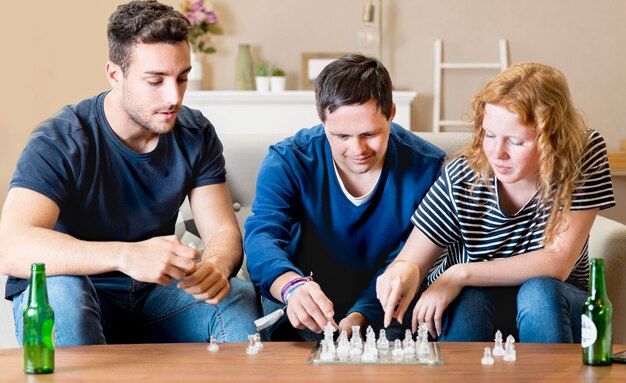 Вид спереди трех друзей, играющих в шахматы