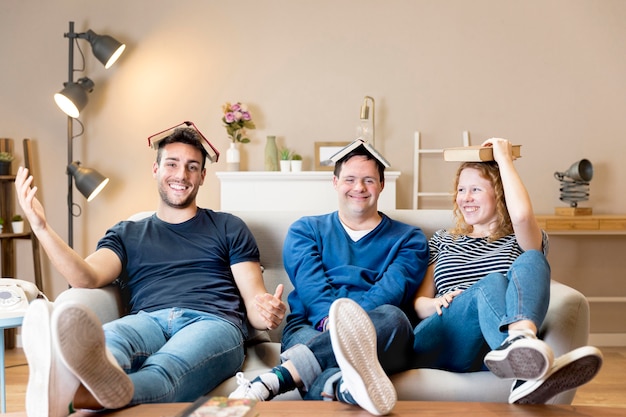 Front view of three friends posing with books