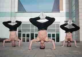 Free photo front view of three shirtless hip hop dancers standing on their heads