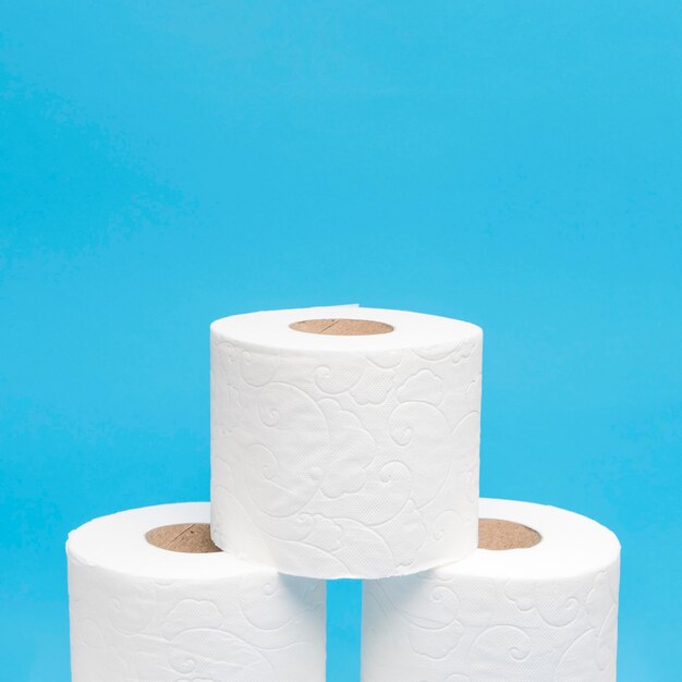 Front view of three stacked toilet paper rolls with copy space