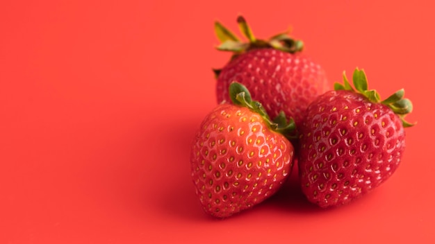 Front view of three strawberries with copy space