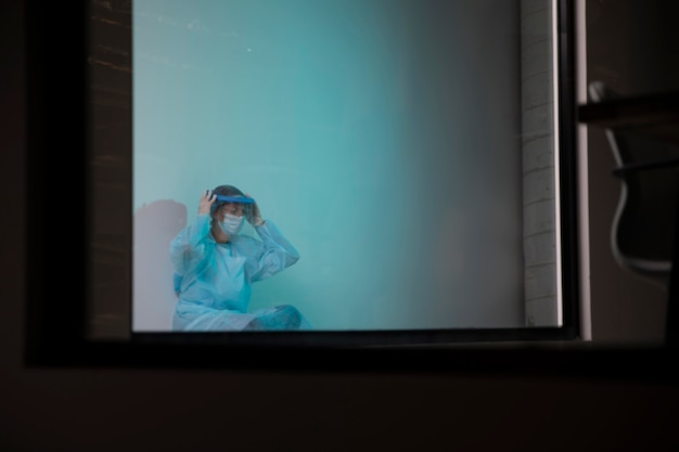 Вид спереди усталый врач, сидящий в больнице