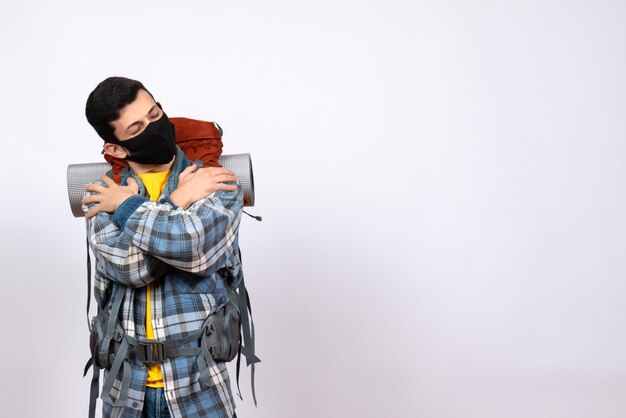 Front view tired male traveler with backpack and mask holding himself