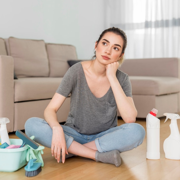 Free photo front view of tired woman with cleaning supplies