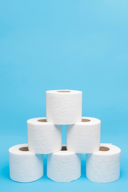 Front view of toilet paper rolls stacked in pyramid shape