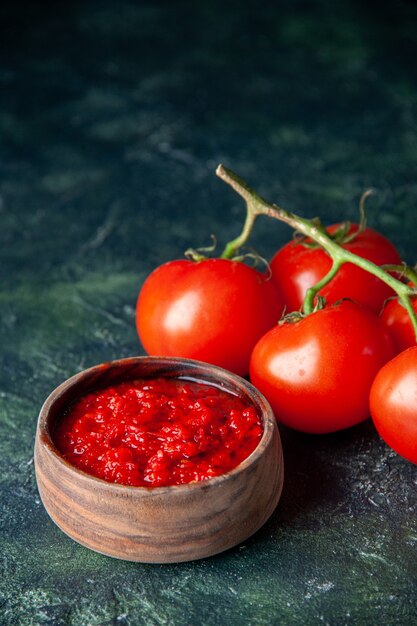 진한 파란색 표면에 신선한 빨간 토마토가 들어간 전면 토마토 소스 토마토 붉은 색 조미료 후추 소금