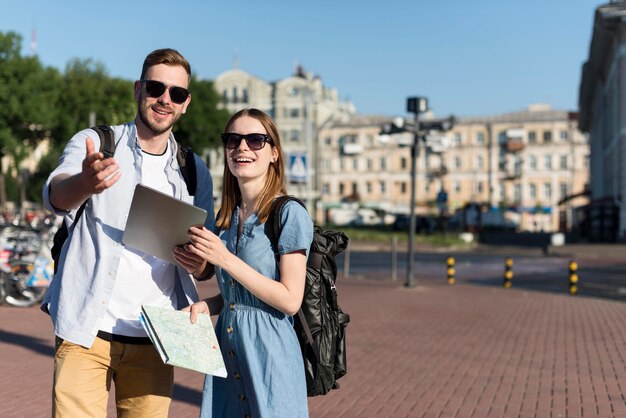 Front view of tourist couple holding tablet