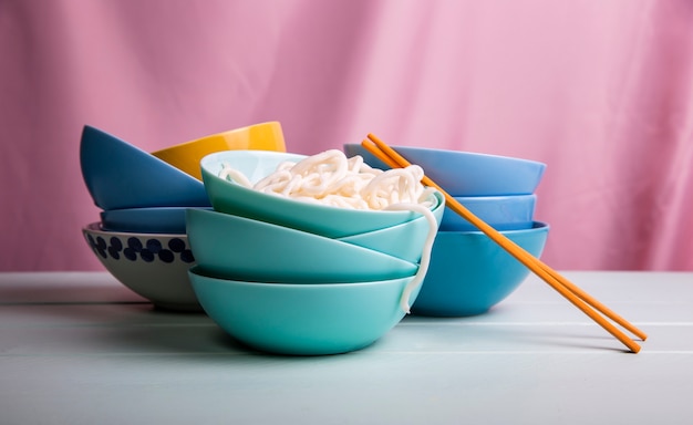 Free photo front view towers of bowls with ramen and chopsticks