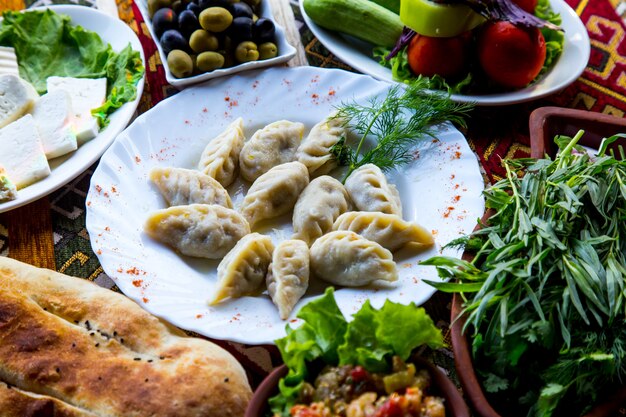 Вид спереди традиционное азербайджанское блюдо гюрза с зеленью и овощами