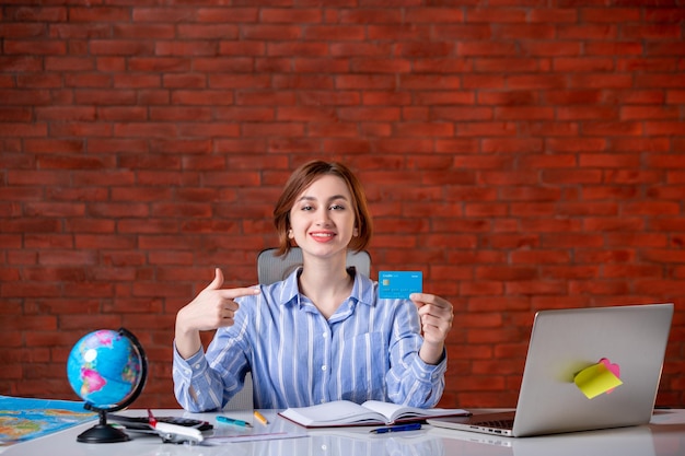 Free photo front view travel agent behind her working place map indoors manager operator agency world document occupation worker