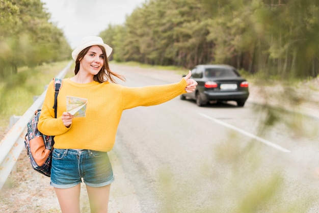 Free photo front view of traveler hitchhiking