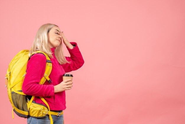 Front view traveler woman with backpack holding coffee cup closing eyes