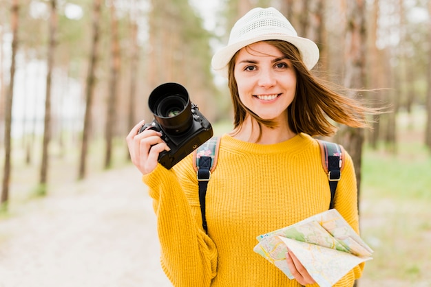 Front view of traveling woman holding camera