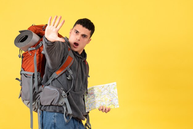 Front view traveller man with backpack holding map making stop sign