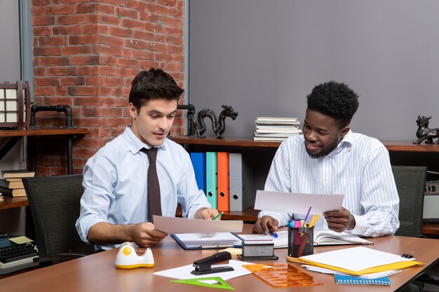 Front view two businessmen in formal wear working together in office