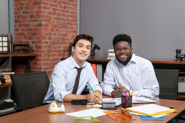 Front view two businessmen looking at camera in office