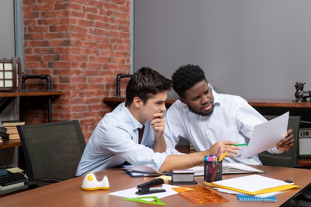 Front view two businessmen satisfying working together in office