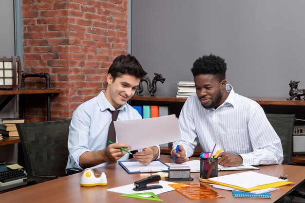 Front view two busy businessmen satisfying working together