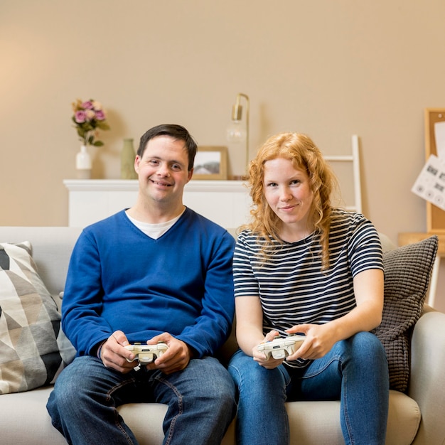 Front view of two friends playing video games at home