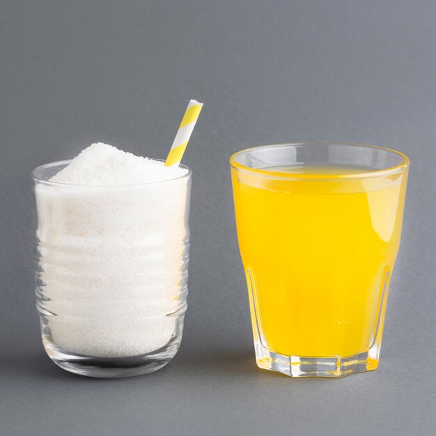 Front view of two glasses with soft drink and sugar