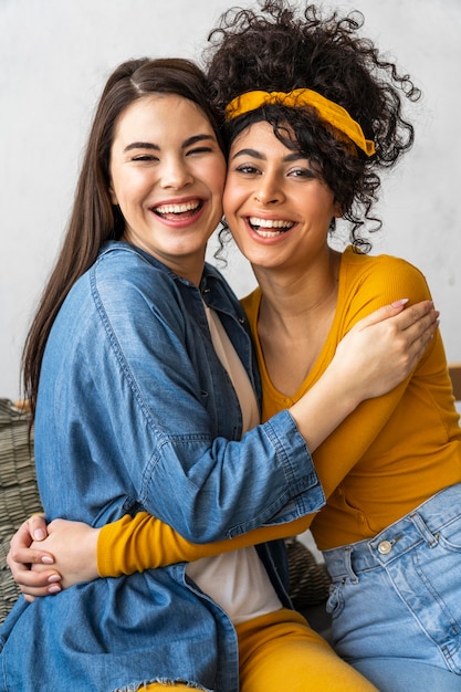 Front view of two happy women smiling and embracing each other