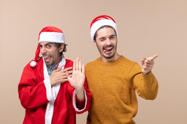 Front view two men one looking at camera with blinked eye on beige isolated background