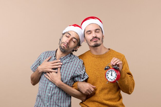 Free photo front view two men sleeping while hugging each other on beige isolated background