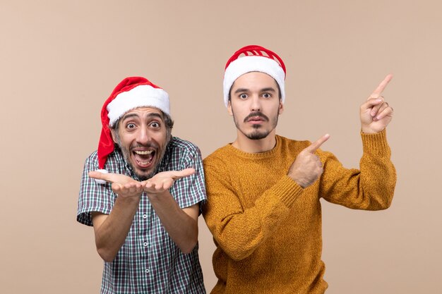 Front view two men with santa hats both showing something on isolated background