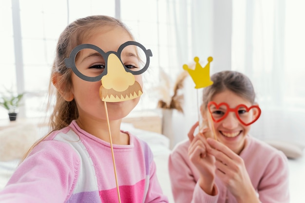 Front view of two sisters at home taking cute selfie