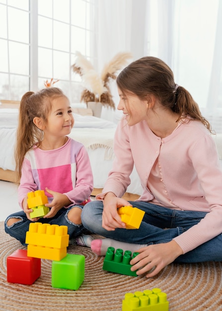 Front view of two sisters playing with toys