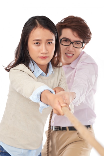 Front view of two young Asian people pulling rope to win the competition