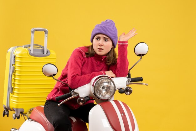 Front view uneasy young girl on moped looking at something