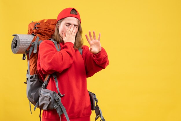 Front view upset traveller woman in red backpack making stop sign