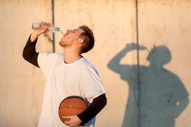 フロントビュー都市バスケットボール選手の水分補給