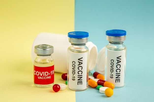 노란색-파란색 배경에 다른 약으로 covid에 대한 전면보기 백신