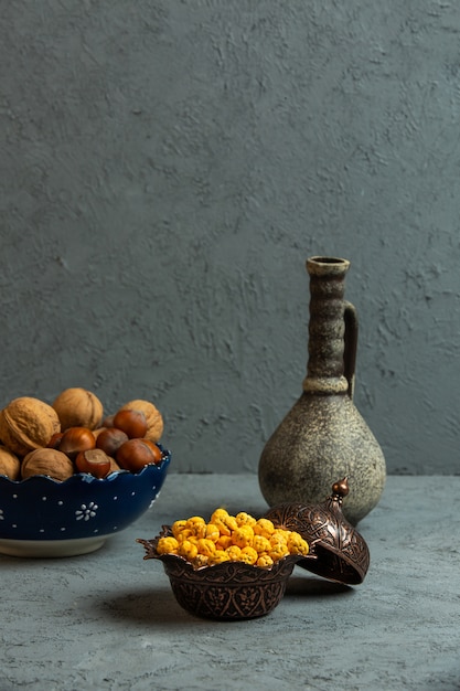 Front view vase with nuts and a jug